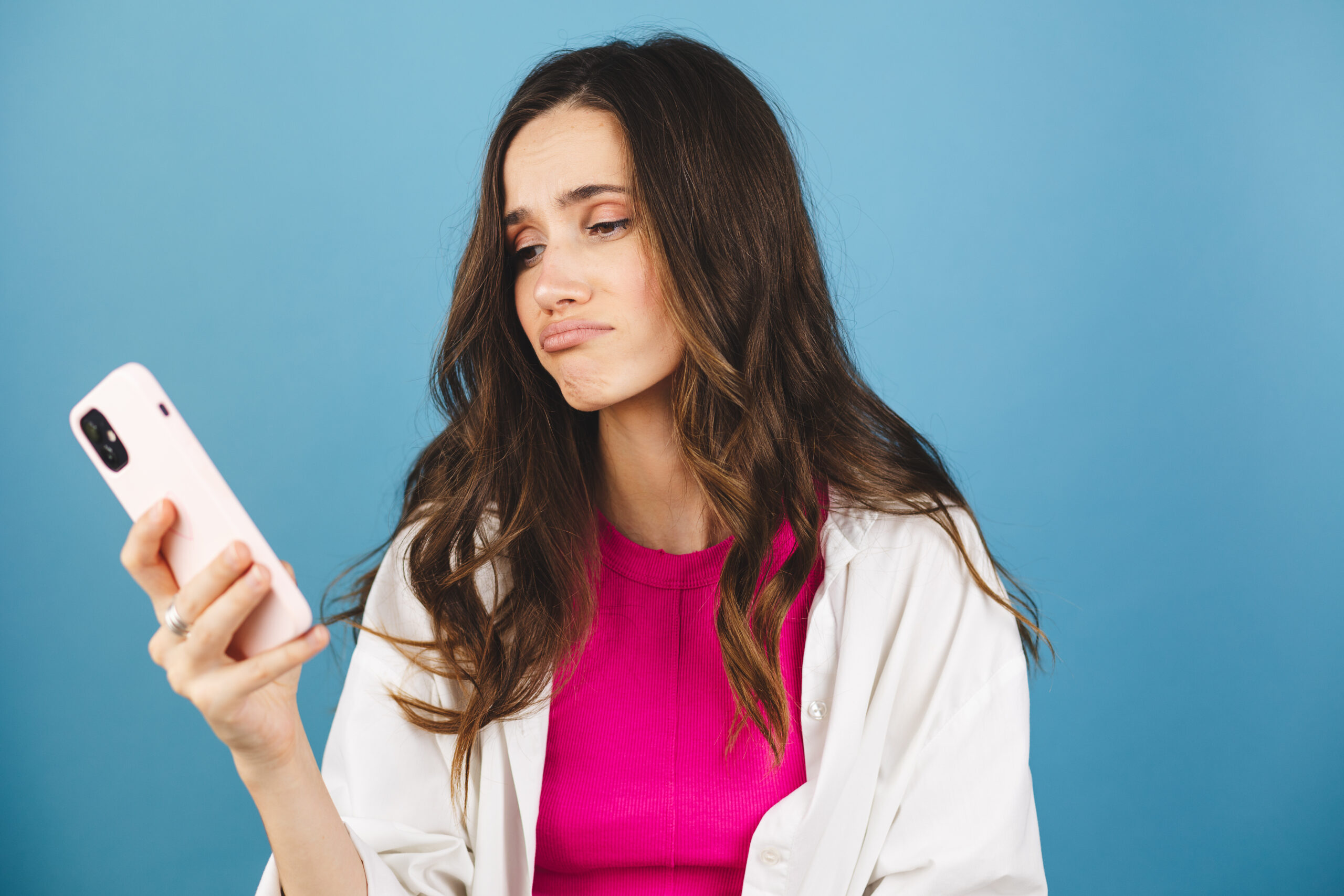 Women looking at phone negatively. Spend less time on phone.