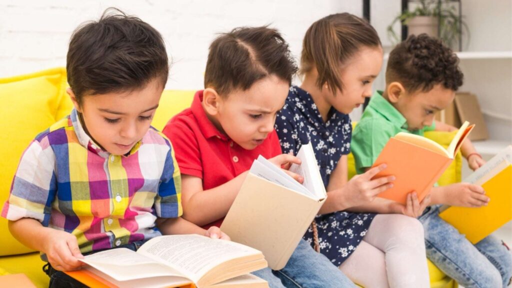 Kids reading books on a yellow couch