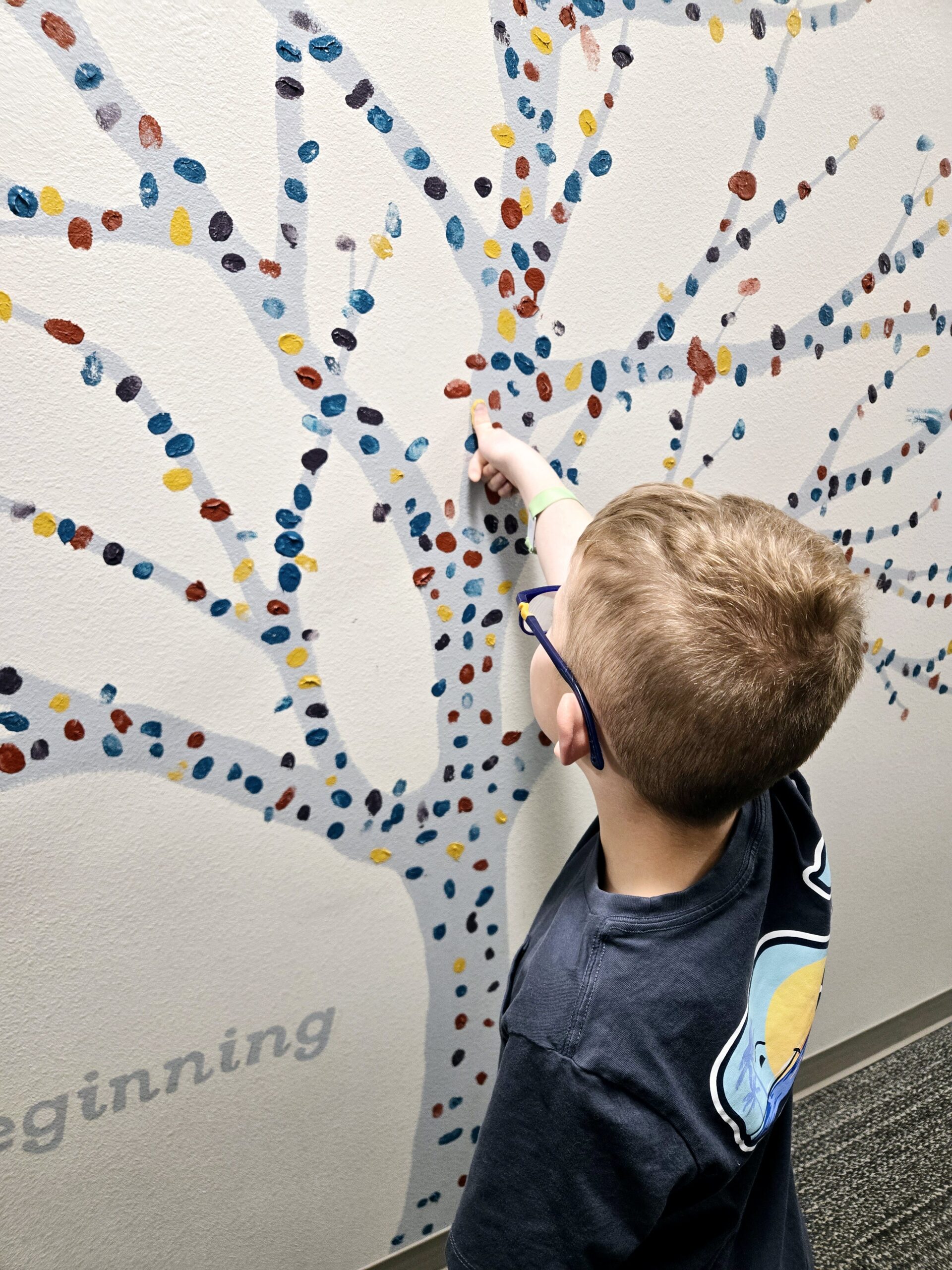 Boy putting his thump print up at Visions Eye Care